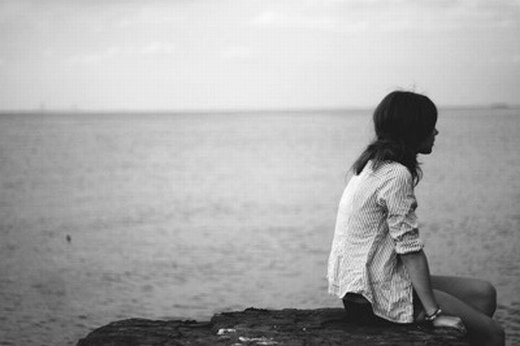 心情失落的女孩坐在海边